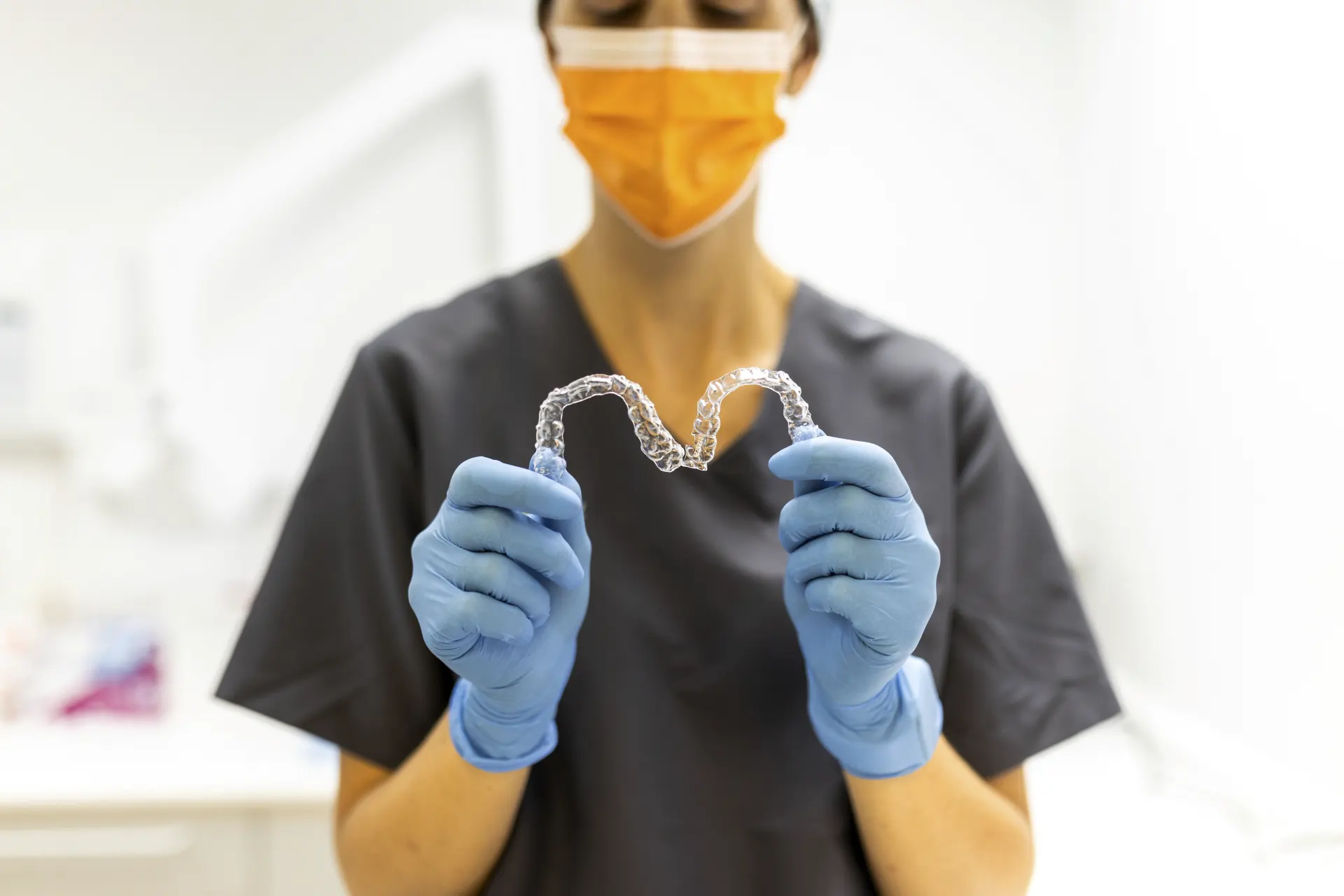 Mujer sujetando dos férulas de ortodoncia invisible Invisalign